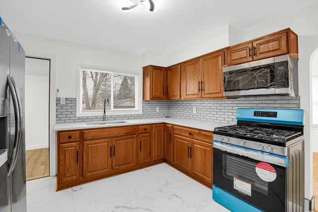 a kitchen with stainless steel appliances granite countertop a stove a sink and a microwave