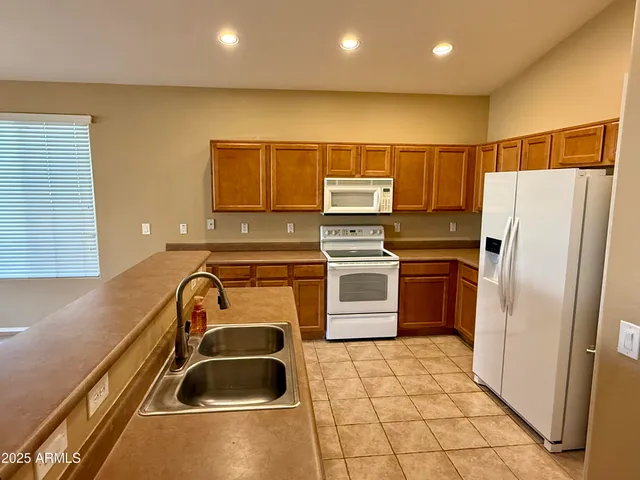a kitchen with a refrigerator a sink and a stove top oven