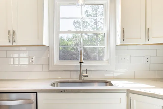 a kitchen with stainless steel appliances granite countertop a refrigerator sink and white cabinets