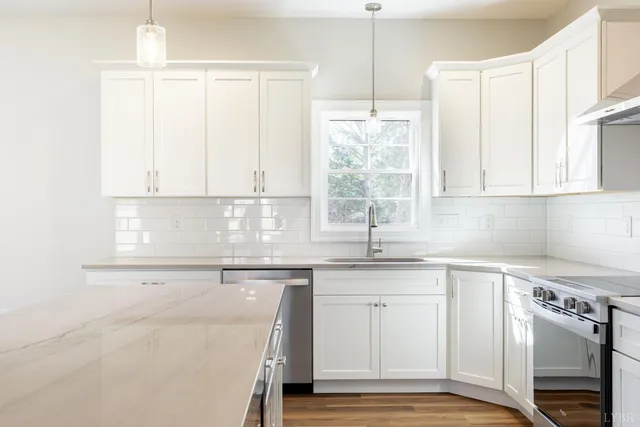 a kitchen with stainless steel appliances granite countertop a sink a stove and a refrigerator