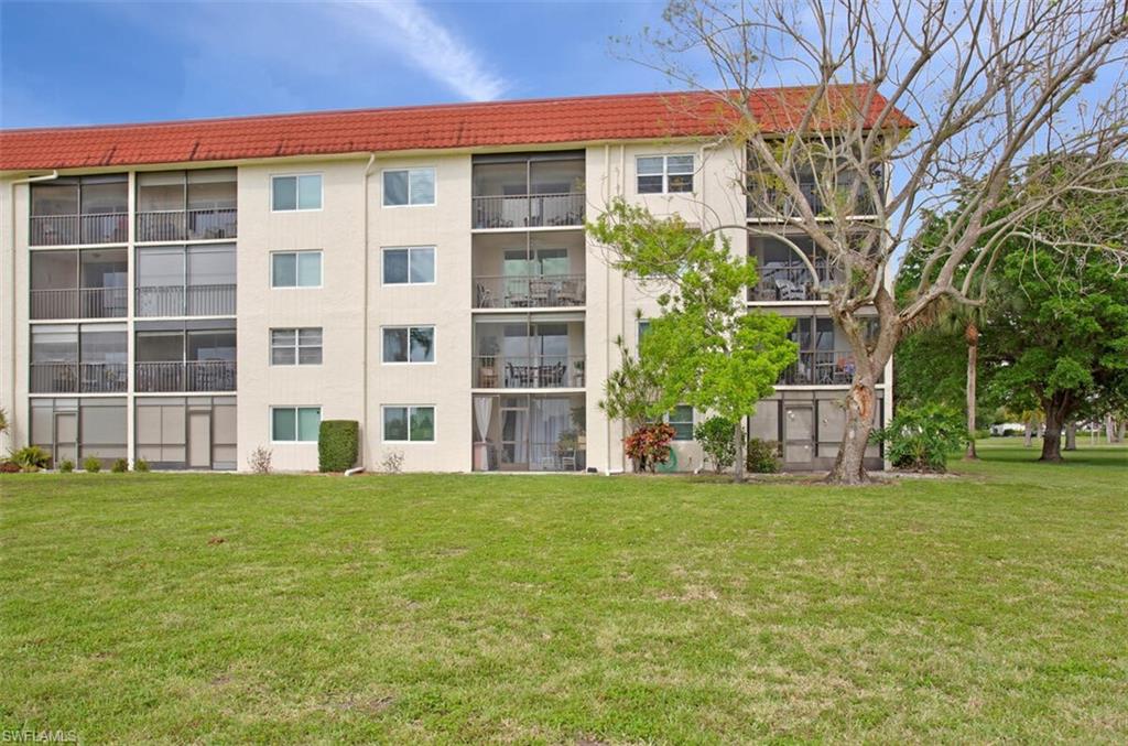 4380 27th Court Southwest, Unit 202 Naples, FL 34116 - Photo 17 of 24 a view of a building with a yard