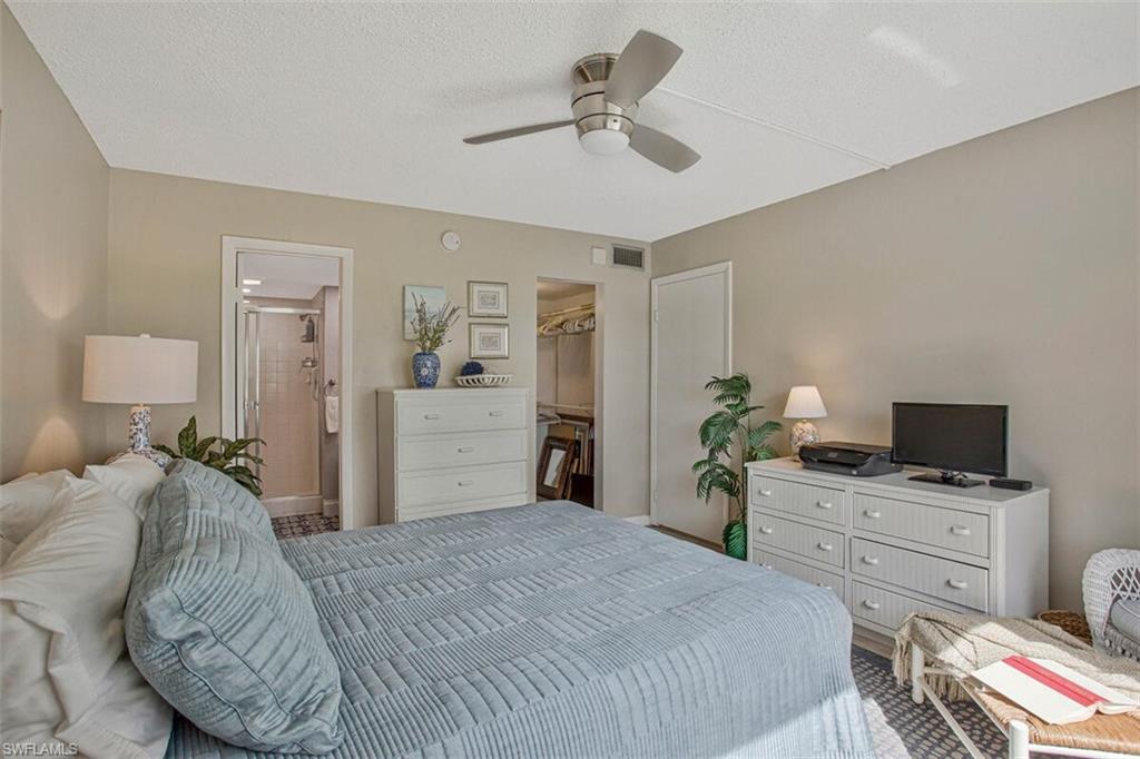 4380 27th Court Southwest, Unit 202 Naples, FL 34116 - Photo 2 of 24 a bedroom with a bed and a chandelier