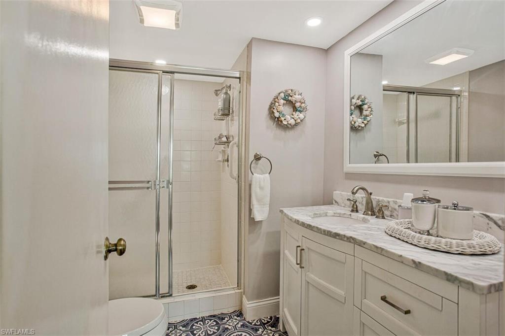 4380 27th Court Southwest, Unit 202 Naples, FL 34116 - Photo 5 of 24 a bathroom with a granite countertop sink mirror shower and toilet