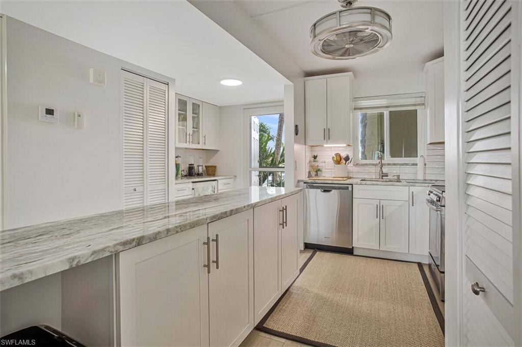 4380 27th Court Southwest, Unit 202 Naples, FL 34116 - Photo 7 of 24 a kitchen with a sink cabinets and window