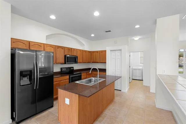 a kitchen with stainless steel appliances granite countertop a refrigerator and a sink