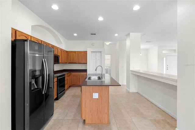 a kitchen with stainless steel appliances granite countertop a refrigerator a sink and a stove