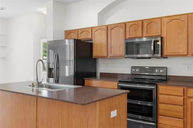 a kitchen with stainless steel appliances wooden cabinets and a stove top oven