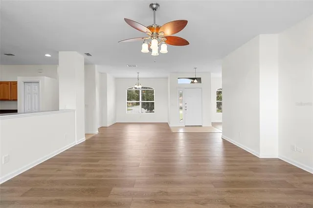 a view of an empty room with window and wooden floor
