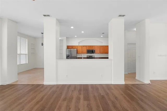 a view of kitchen with wooden floor and electronic appliances