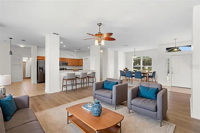 a living room with furniture kitchen view and a chandelier