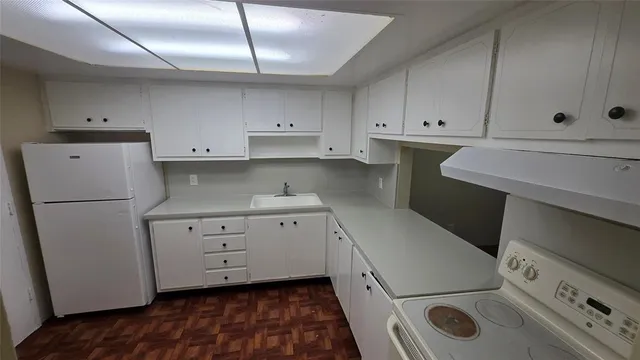 a kitchen with granite countertop white cabinets and white appliances