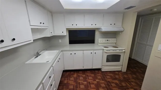 a kitchen with granite countertop white cabinets and white appliances