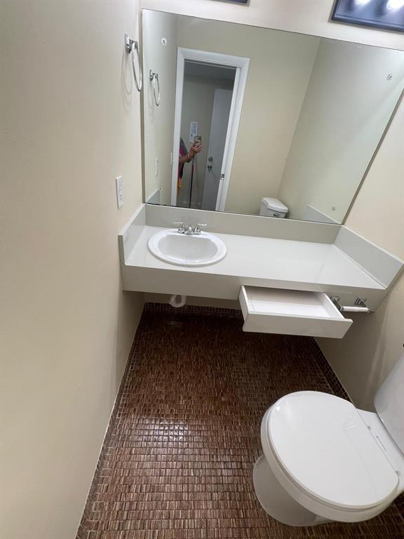 16800 Northeast 15th Avenue, Unit 310 North Miami Beach, FL 33162 - Photo 5 of 23 a bathroom with a sink a toilet a mirror and vanity