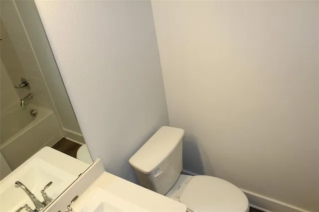 a white toilet sitting next to a bath tub