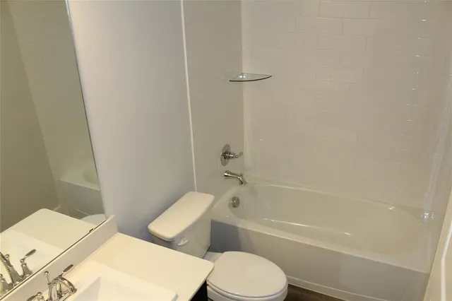 a white toilet and tub sitting next to a bathroom sink