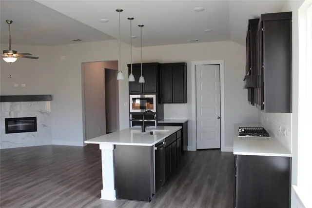 a kitchen with kitchen island a counter space a sink appliances and cabinets
