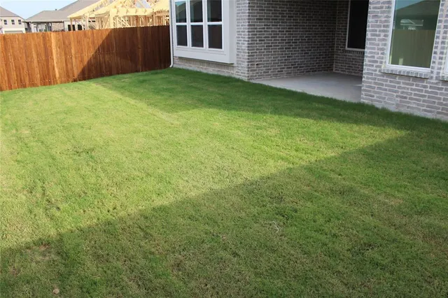 a view of a backyard with brick wall and a small cabin