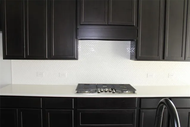 a kitchen with a sink a stove and cabinets
