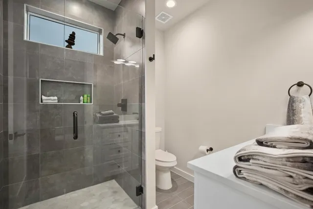 a bathroom with a sink a toilet and shower