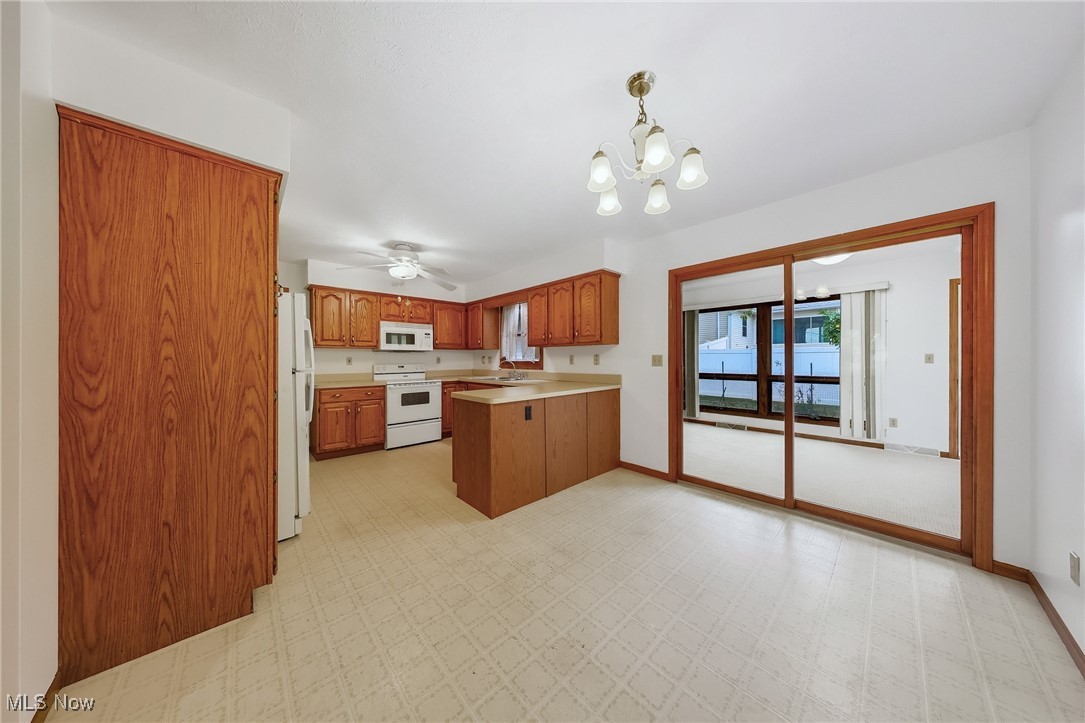 425 Overlook Drive Rittman, OH 44270 - Photo 16 of 44 Kitchen with brown cabinetry, white appliances, light floors, light countertops, and a peninsula