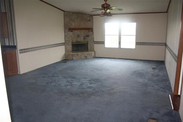 an empty room with windows and fireplace