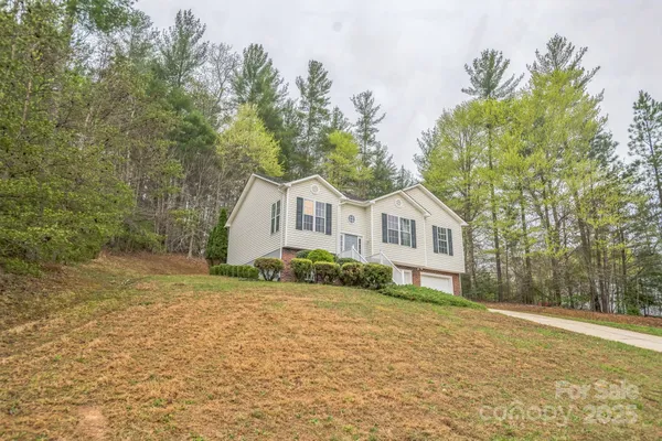a front view of a house with a yard and trees