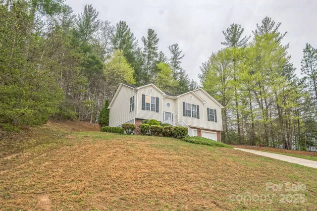 a front view of a house with a yard and trees