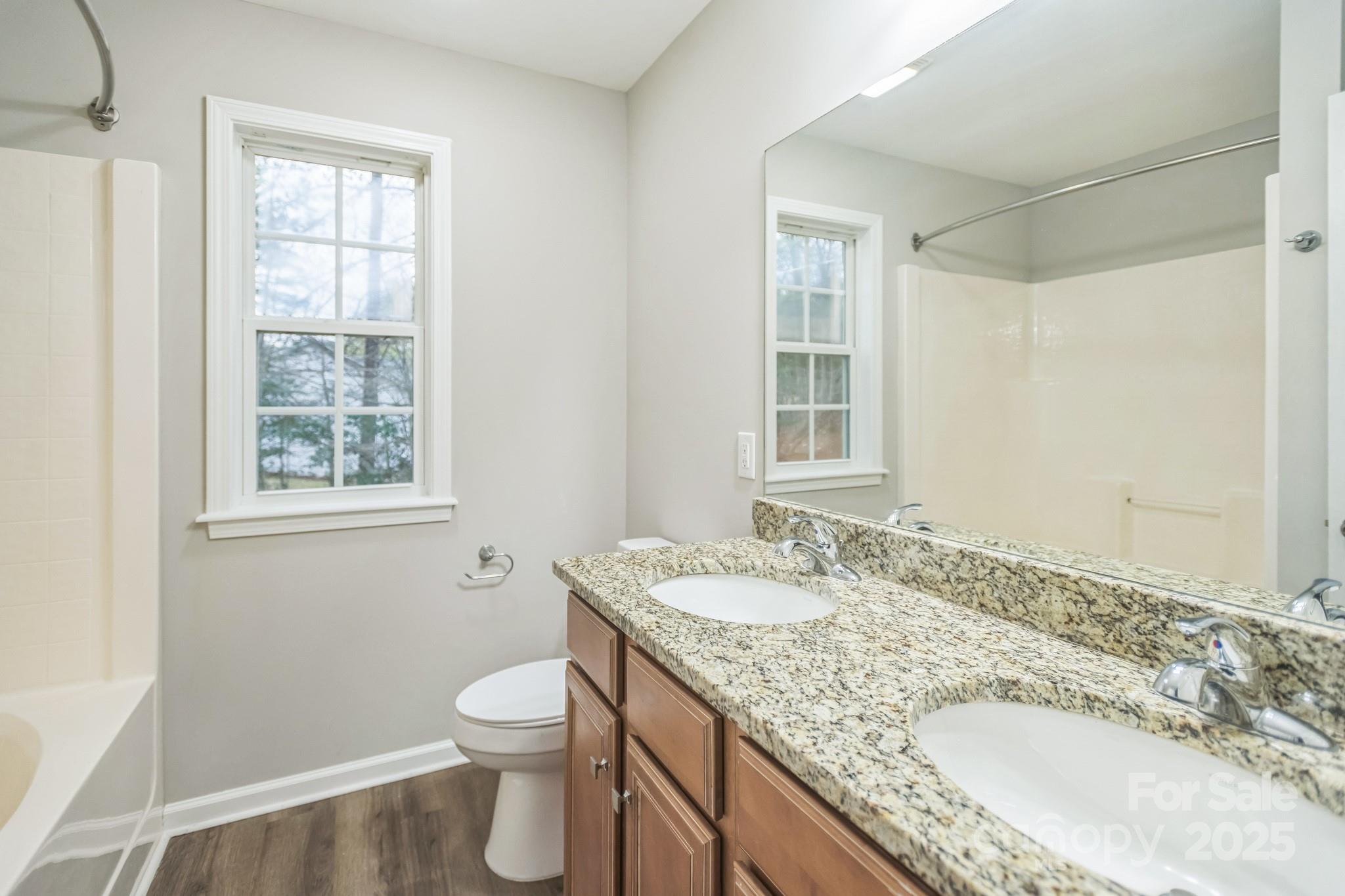 240 Doe Run Morganton, NC 28655 - Photo 10 of 15 a bathroom with a granite countertop sink a toilet and a window