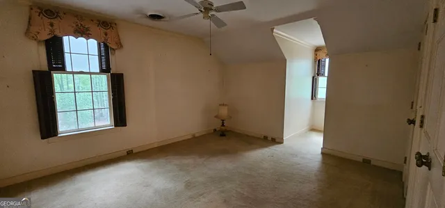 a view of a hallway with wooden floor and stairs