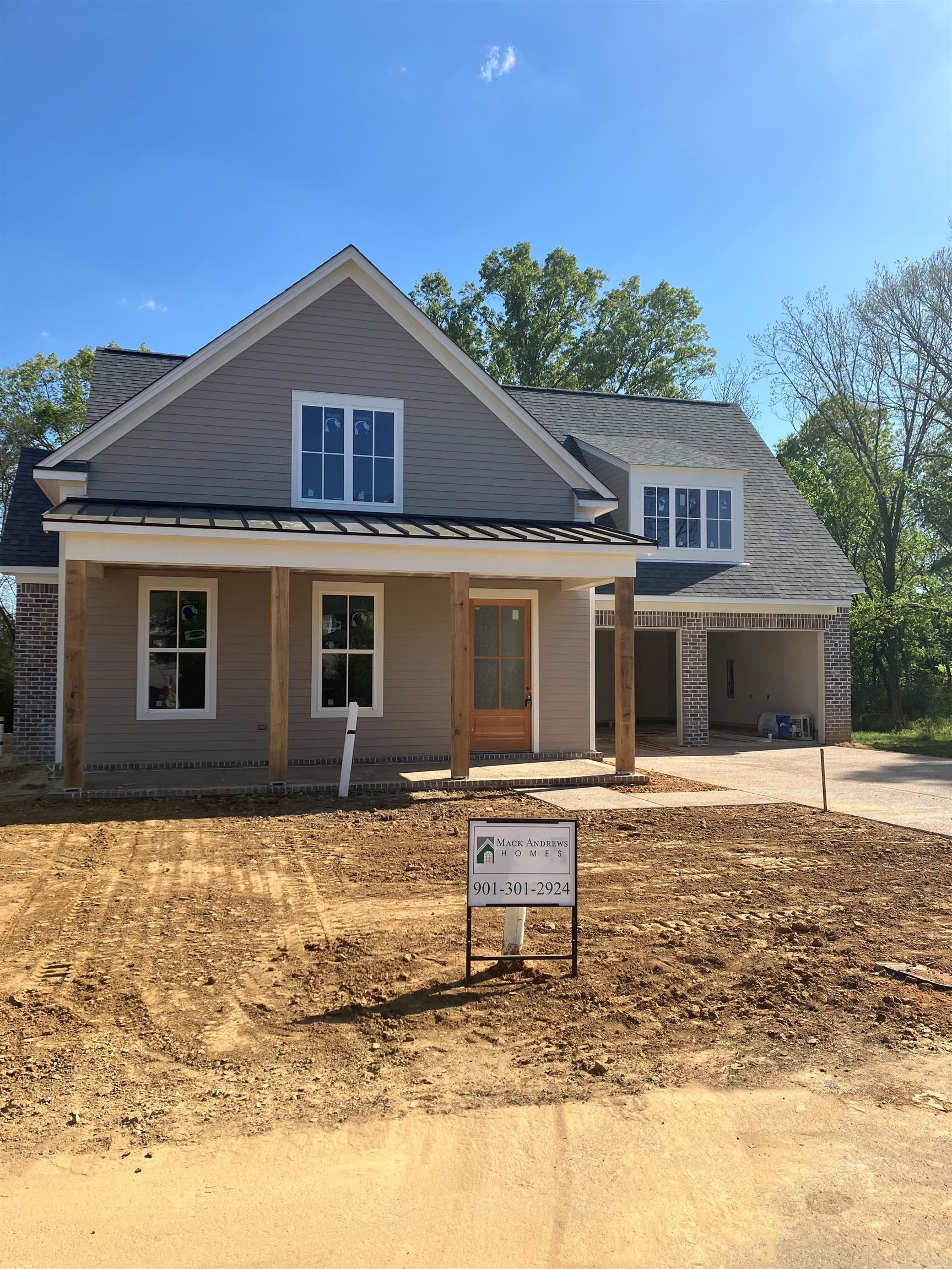 267 Mossberry Lane Collierville, TN 38017 - Photo 1 of 3 View of front of home featuring covered porch, driveway, brick siding, a standing seam roof, and a garage