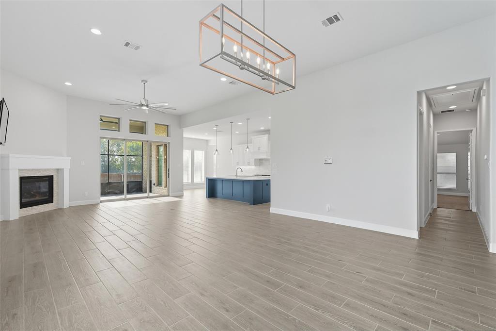 1557 Ripasso Way McLendon-Chisholm, TX 75032 - Photo 12 of 31 an empty room with wooden floor fireplace and windows