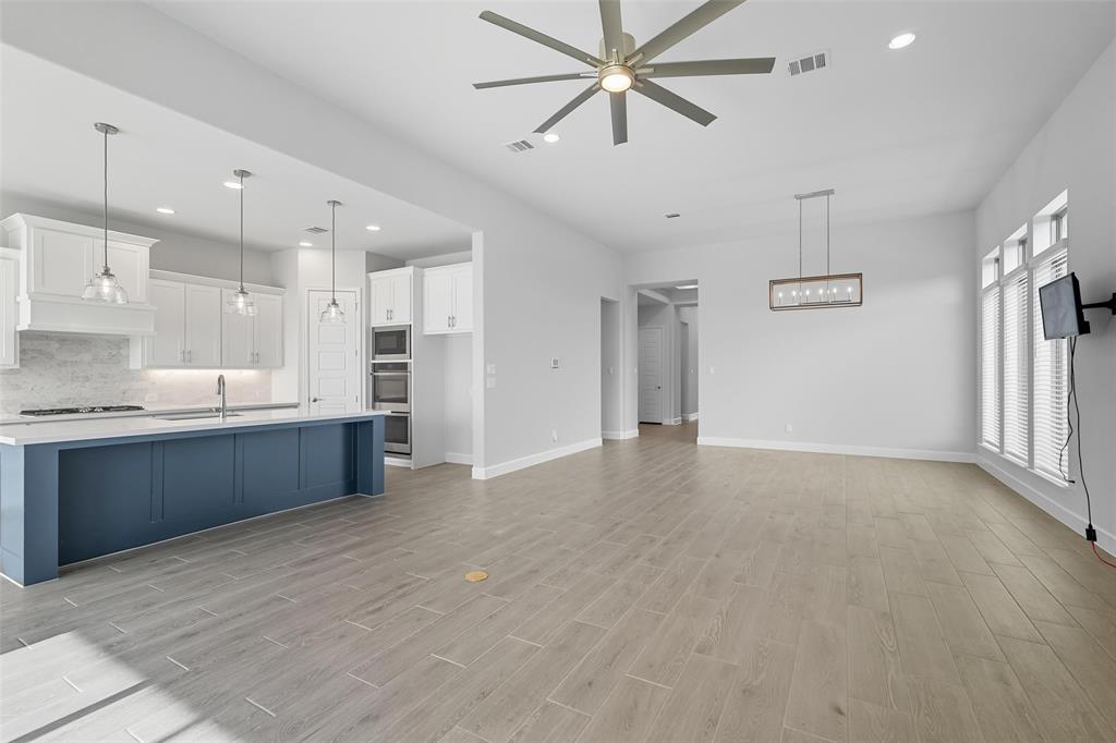 1557 Ripasso Way McLendon-Chisholm, TX 75032 - Photo 13 of 31 a large kitchen with stainless steel appliances kitchen island a refrigerator sink and white cabinets