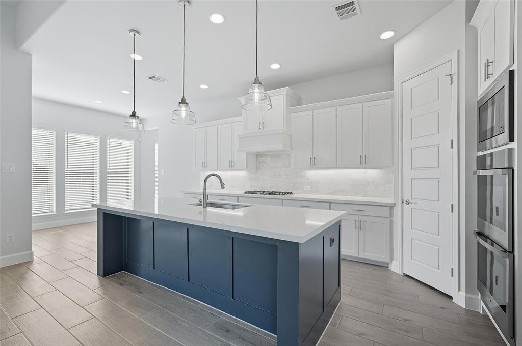1557 Ripasso Way McLendon-Chisholm, TX 75032 - Photo 15 of 31 a kitchen with a sink kitchen island and stainless steel appliances
