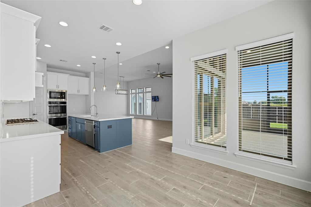 1557 Ripasso Way McLendon-Chisholm, TX 75032 - Photo 17 of 31 a large kitchen with stainless steel appliances kitchen island granite countertop a refrigerator a stove a sink and a granite countertops with wooden floor