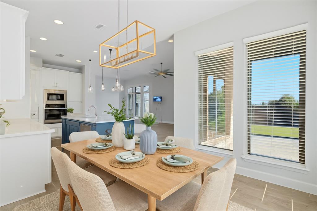 1557 Ripasso Way McLendon-Chisholm, TX 75032 - Photo 18 of 31 a view of a dining room with furniture large windows and wooden floor