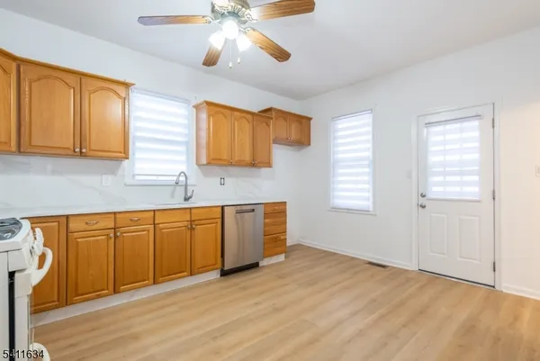 a kitchen with stainless steel appliances granite countertop a stove a sink and a wooden floors