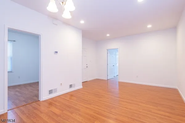 a view of an empty room with wooden floor