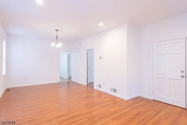 an empty room with wooden floor and ceiling fan