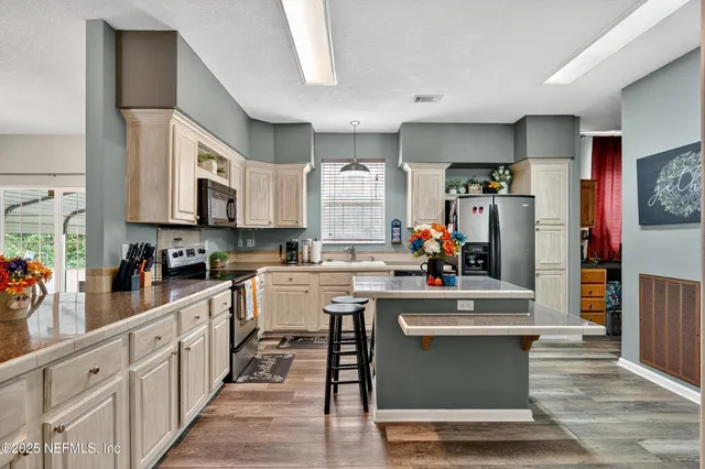 a kitchen with stainless steel appliances granite countertop a stove and cabinets