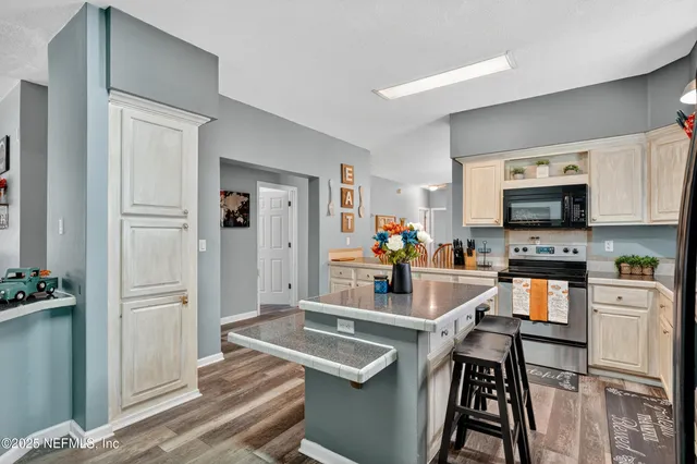 a kitchen with granite countertop a sink stove and refrigerator