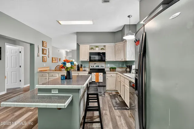 a kitchen with granite countertop a sink stove and refrigerator