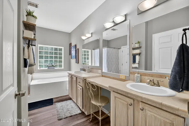 a bathroom with a granite countertop sink a mirror and a bathtub
