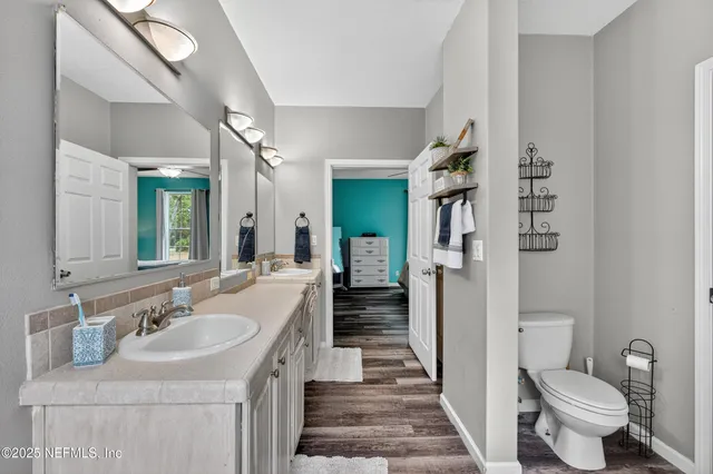 a bathroom with a sink a toilet and a large mirror