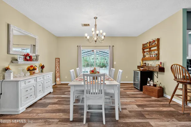 a view of a dining room with furniture a chandelier and wooden floor