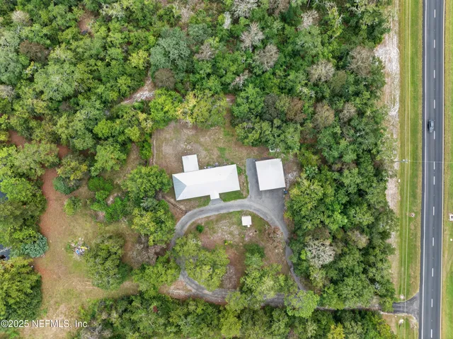 an aerial view of a house with a yard and lake view
