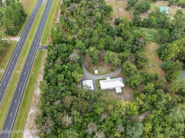 a aerial view of a house with a yard and large trees