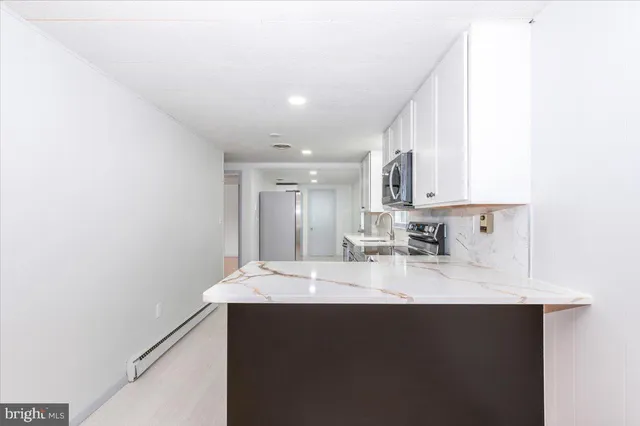 a kitchen with kitchen island sink refrigerator and cabinets