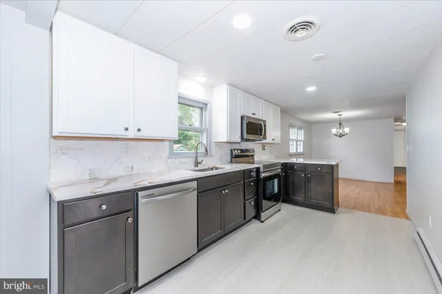 a large kitchen with stainless steel appliances lots of counter top space and a sink