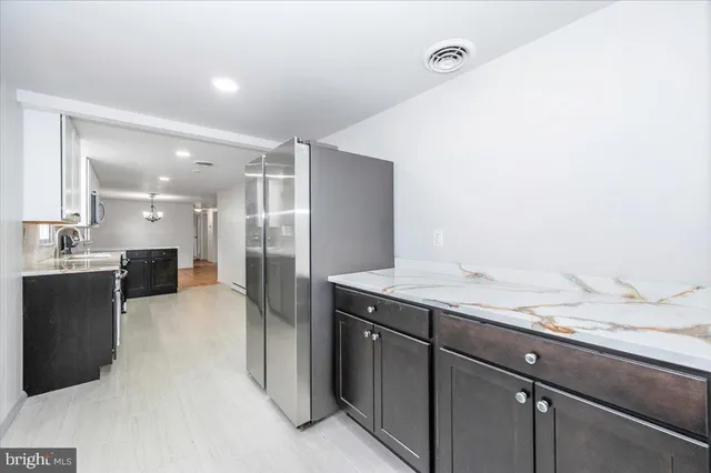 a bathroom with a granite countertop sink a mirror and a shower
