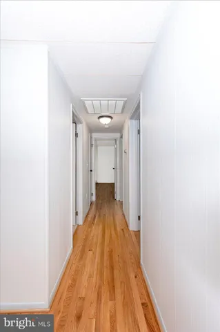 a view of a hallway with wooden floor